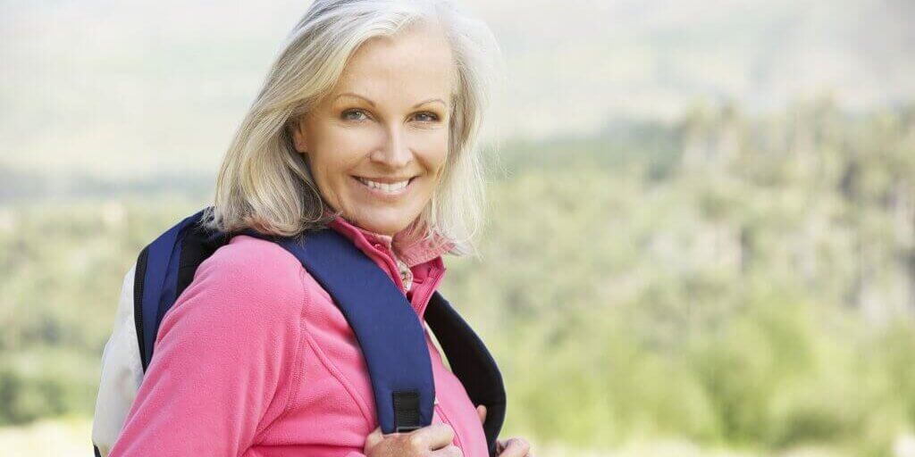 Portrait Of Senior Woman On Hike Smiling At Camera