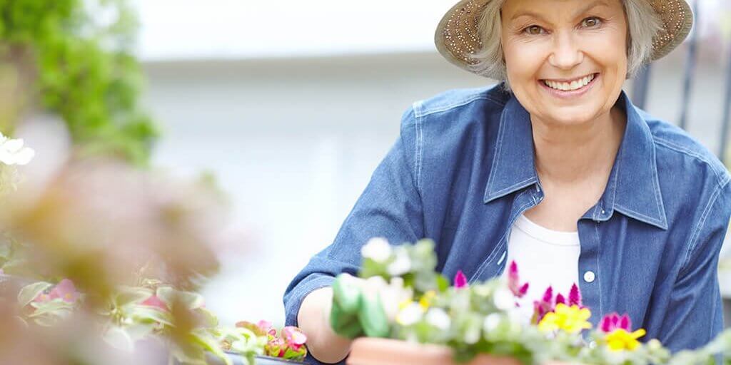 Portrait of a delighted senior woman gardening